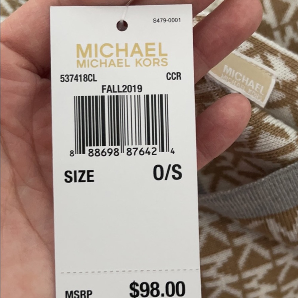 This light brown scarf has small white Michael kors symbols with a grey stripe
